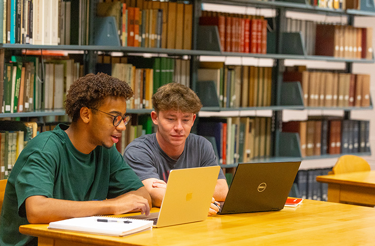Two UL Lafayette students working on laptops in the Library.